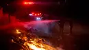 Petugas pemadam kebakaran memadamkan api saat memadamkan kebakaran hutan yang disebut Kebakaran Dataran Tinggi di Aguanga, California, Senin, 30 Oktober 2023. (AP Photo/Ethan Swope)