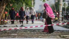 Pejalan kaki melintasi trotoar yang sedang direvitalisasi di kawasan Kramat Raya, Jakarta, Rabu (6/11/2019). Ketua Koalisi Pejalan Kaki Alfred Sitorus menilai pengerjaan revitalisasi trotoar membahayakan pejalan kaki karena tidak ada ruang sementara untuk melintas. (Liputan6.com/Faizal Fanani)
