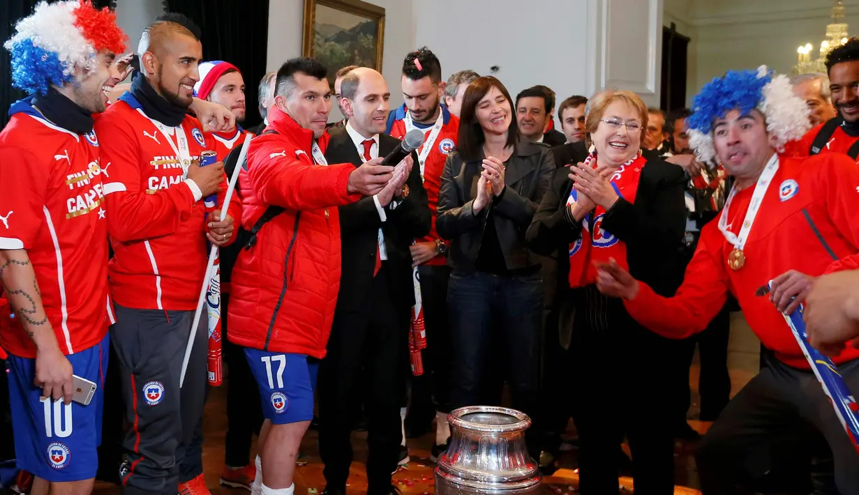 pemain Cile merayakan kegembiraan bersama Presiden Cile, Michelle Bachelet, di Istana Presiden. (REUTERS/Rodrigo Garrido)