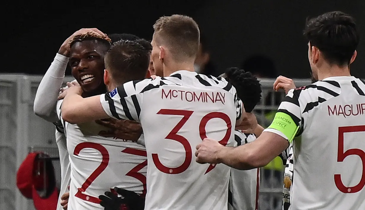 Gelandang Manchester United, Paul Pogba (kiri) bersama rekan setim merayakan gol yang dicetaknya ke gawang AC Milan dalam laga leg kedua babak 16 besar Liga Europa 2020/2021 di San Siro Stadium, Milan, Kamis (18/3/2021). Manchester United menang 1-0 atas AC Milan. (AFP/Marco Bertorello)