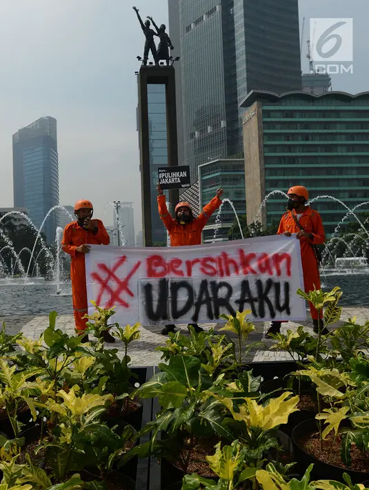 Aktivis membentangkan spanduk saat kampanye damai terkait buruknya udara Jakarta di Bundaran HI, Rabu (5/12). Aksi tersebut sebagai bentuk kekecewaan kepada pemerintah akibat lalai dalam menangani polusi udara di Jakarta. (Merdeka.com/Imam Buhori)