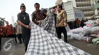 Presiden Joko Widodo melihat barang tekstil impor ilegal di Direktorat Jenderal Bea dan Cukai, Jakarta, Jumat (16/10/2015). Jokowi menyebut, maraknya impor tekstil ilegal merusak industri nasional. (Liputan6.com/Faizal Fanani)