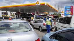 Polisi mengarahkan pengendara yang antre membeli bahan bakar yang masih tersedia di salah satu pompa bensin di Hurlingham, ibu kota Nairobi, 14 April 2022. Selama berminggu-minggu Kenya menderita kekurangan di pompa bensin dengan ada yang tidak memiliki bahan bakar sama sekali (AP Photo/Khalil Senos