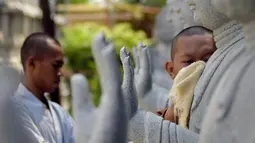 Dua orang bhiksu membersihkan patung di  Vihara Mahavira Graha Semarang , Sabtu ( 21/5/2016). Terdapat 120 patung Budha di Vihara Mahavira Graha Semarang. (Gholib)