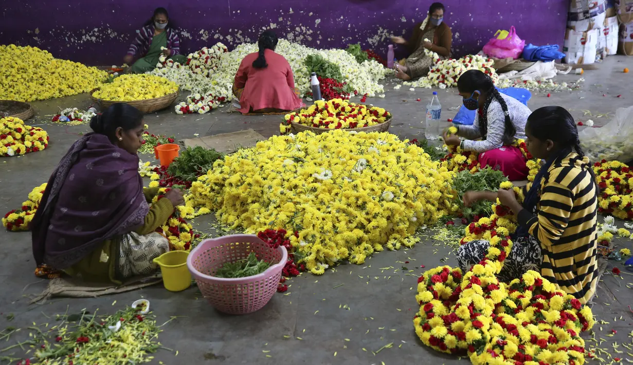 Penjual bunga menyiapkan karangan bunga di pasar grosir di Bengaluru, India, Kamis (24/9/2020). Negara berpenduduk 1,3 miliar itu diperkirakan akan menjadi negara terparah pandemi COVID-19 dalam beberapa minggu, melampaui Amerika Serikat. (AP Photo/Aijaz Rahi)