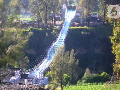 Pekerja menyelesaikan finishing jembatan kaca Seruni Point di Pasuruan, Jawa Timur, Minggu (30/4/2023). Jembatan kaca yang membentang sepanjang 120 meter dengan lebar 1,8 meter di atas jurang dengan kedalaman 80-100 meter ini diperkirakan dapat digunakan wisatawan pada Oktober nanti. (merdeka.com/Arie Basuki)
