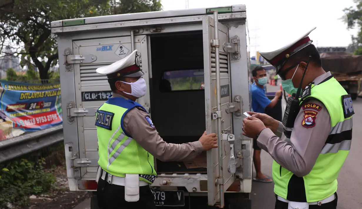 Petugas kepolisian melakukan pengecekan terhadap mobil box yang keluar Tol Merak, Banten, Senin (18/5/2020). Pemeriksaan (check point) tersebut terkait larangan mudik guna penyekatan atau memeriksa kemungkinan pemudik yang akan keluar dari wilayah Jabodetabek. (Liputan6.com/Angga Yuniar)