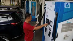 Pemilik kendaraan melakukan pengisian daya kendaraan listrik di SKPLU, Jakarta, Minggu (5/1/2025). (Liputan6.com/Angga Yuniar)