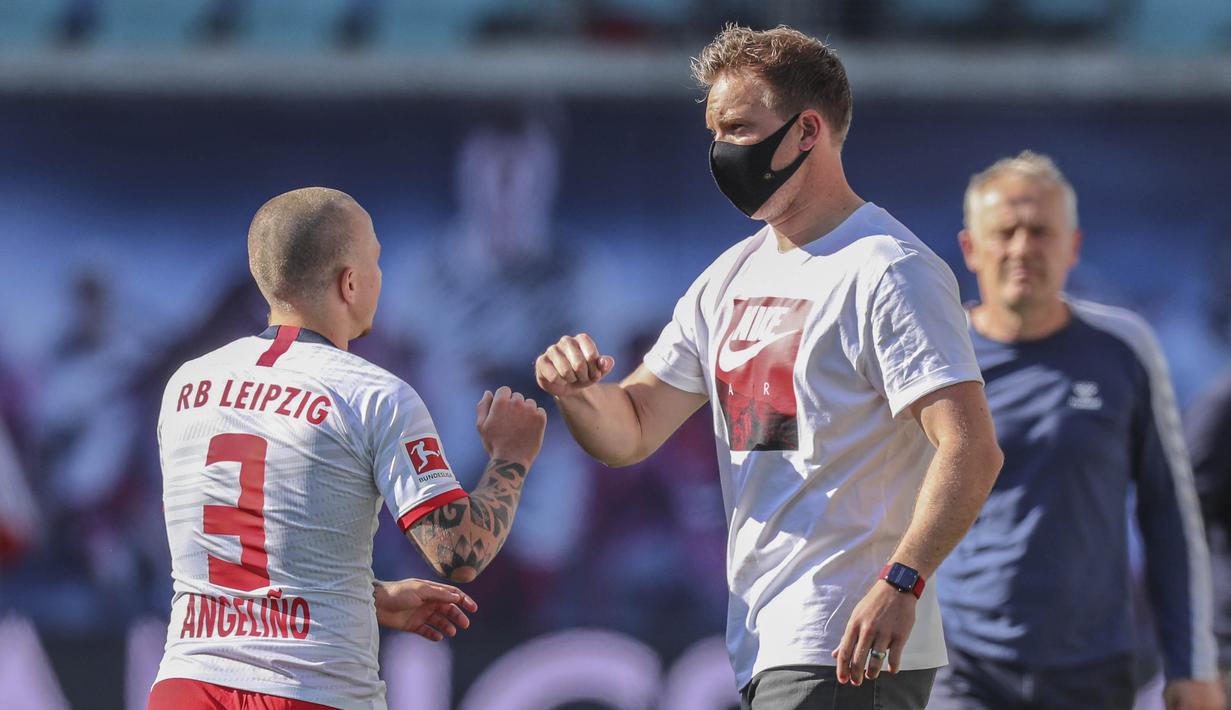 Pelatih RB Leipzig, Julian Nagelsmann, melakukan selebrasi bersama Angelino saat melawan SC Freiburg pada laga Bundesliga di Leipzig, Sabtu (16/5/2020). Pandemi COVID-19 membuat pemain melakukan selebrasi jaga jarak. (AFP/Jan Woitas)