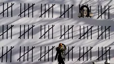 Seorang wanita pejalan kaki melihat mural baru karya seniman misterius Inggris, Banksy di wilayah Manhattan, New York (15/3). Mural ini memprotes penahanan seniman Turki Zehra Dogan karena lukisannya. (AFP Photo/Timothy A. Kliit)