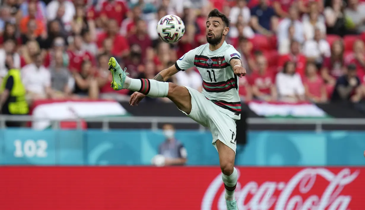 Gelandang Portugal, Bruno Fernandes melompat untuk mengontrol bola saat bertanding melawan Hungaria pada pertandingan grup F Euro 2020 di stadion Ferenc Puskas di Budapest, Hungaria, Selasa (15/6/2021). Portugal menang atas Hungaria 3-0. (AP Photo/Darko Bandic, Pool)