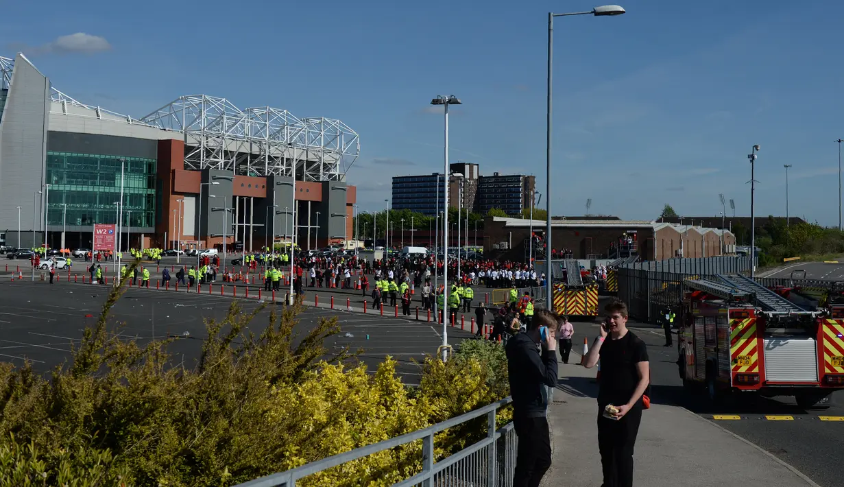 Petugas pemadam kebakaran tiba di Stadion Old Trafford, Inggris, Minggu (15/5). Laga terakhir Liga Inggris antara MU Vs Bournemouth terpaksa dibatalkan setelah ditemukan paket mencurigakan di salah satu tribun Stadion Old Trafford. (Oli SCARFF/AFP)