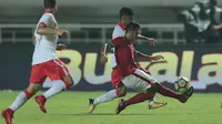 Pemain Timnas Indonesia U-23, Putu Gede Juniantara (kanan) berusaha menghalau bola dari kaki pemain Bahrain pada laga PSSI Anniversary Cup 2018 di Stadion Pakansari, Bogor, (26/4/2018). Bahrain unggul sementara 1-0. (Bola.com/Nick Hanoatubun)