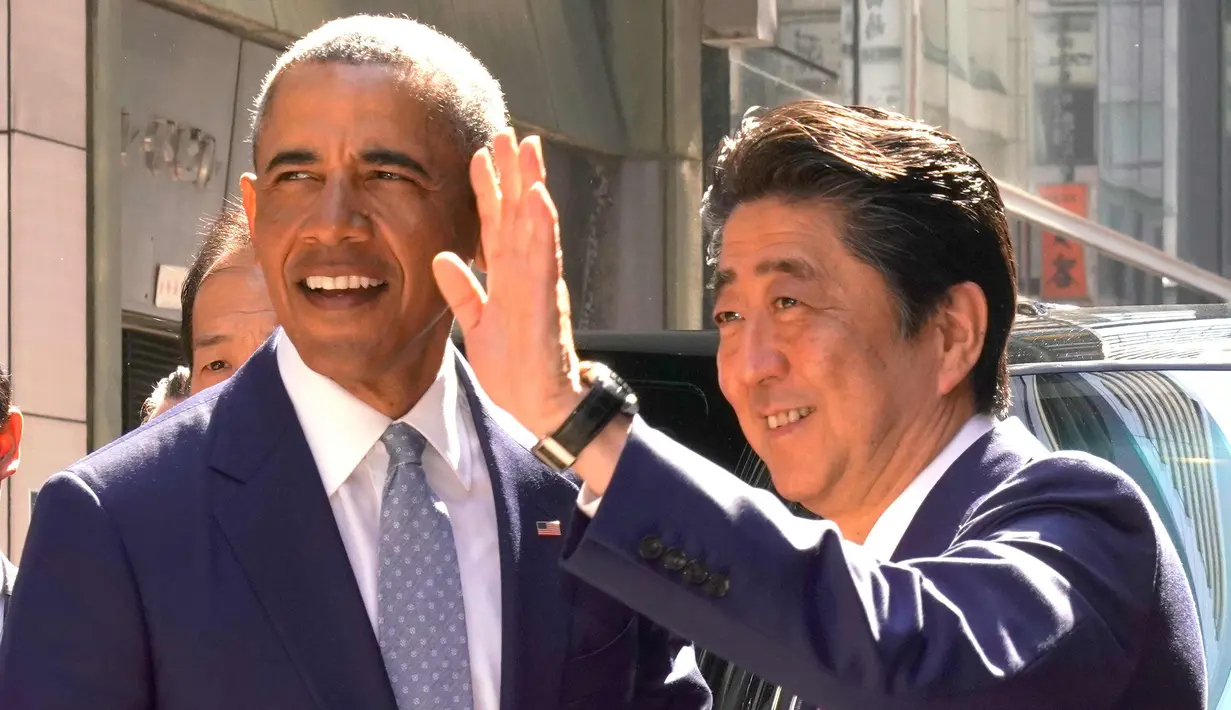 PM Jepang, Shinzo Abe menyambut Presiden AS ke-44 Barack Obama saat tiba di salah satu restoran sushi di kawasan Ginza, Tokyo, Jepang, (25/3). Obama dan Abe makan siang bersama di restoran tersebut. (AP Photo / Shizuo Kambayashi, Pool)