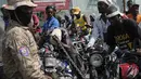 Pengendara sepeda motor mencoba masuk ke dalam pompa bensin saat terjadi kelangkaan bahan bakar nasional di Port-au-Prince, Haiti, Minggu (31/10/2021). Kelangkaan BBM membuat warga Haiti sulit mendapatkan transportasi dan memaksa sejumlah bisnis menghentikan operasi. (AP Photo/Matias Delacroix)