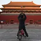 Seorang anak laki-laki mengambil foto di luar Kota Terlarang yang ditutup di Beijing pada Selasa (4/2/2020). Mencegah korban virus corona bertambah, China menutup  banyak destinasi wisata termasuk Kota Terlarang yang ditutup untuk kunjungan wisatawan sejak 24 Januari 2020 lalu. (GREG BAKER/AFP)