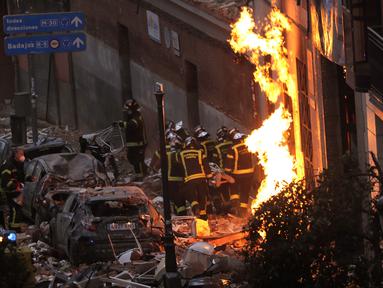 Petugas pemadam kebakaran membawa mayat di samping bangunan yang rusak di Jalan Toledo menyusul ledakan di pusat kota Madrid, Spanyol, Rabu (20/1/2021). Ledakan dahsyat yang disebabkan kebocoran gas telah menghancurkan bangunan di jantung ibu kota Spanyol, Madrid. (AP Photo/Manu Fernandez)