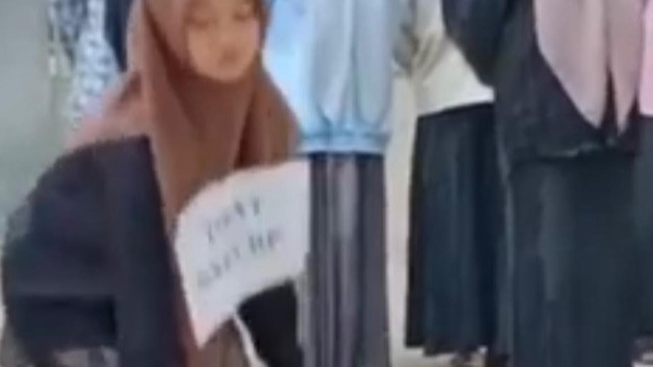 Santriwati ini terllihat berdiri di depan teman-temannya yang lain. Ia dihukum lantaran membawa HP di pondok pesantren. Pondok pesantren ini menetapkan aturan tak boleh membawa telepon genggam.