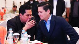 Menteri BUMN, Erick Thohir, berbincang dengan Direktur Utama Ketua Perbasi, Budisatrio Djiwandono, saat peresmian kerja sama antara Bank Mandiri dengan IBL di Plaza Mandiri, Jakarta, Selasa (1/7/2025). (Bola.com/Abdul Aziz)