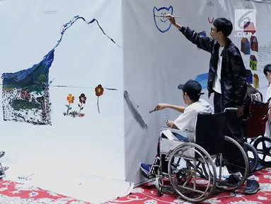 Penyandang disabilitas melukis mural di kanvas sepanjang 20 meter di Balai Kota DKI Jakarta, Kamis (11/10). Kegiatan tersebut diadakan sebagai sarana untuk para penyandang disabilitas berkarya. (Liputan6.com/Immanuel Antonius)