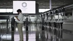 Seorang pria yang mengenakan masker untuk membantu mengekang penyebaran virus corona berdiri di konter tiket kosong pada sore hari di Bandara Internasional Narita, Tokyo, Selasa siang (1/6/2021). Perpanjangan pembatasan ini membuat sejumlah bandara terpantau sepi penumpang. (AP Photo/Eugene Hoshiko)