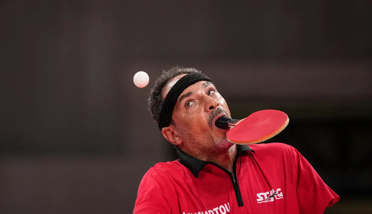 Atlet para-tenis meja Mesir, Ibrahim Elhusseiny Hamadtou melakukan servis saat melawan Chao Chen dari China pada laga Group E kelas 6 Tenis Meja Putra Paralimpiade Tokyo 2020 di Tokyo Metropolitan Gymnasium, Jumat (27/8/2021). (Yasuyoshi CHIBA / AFP)