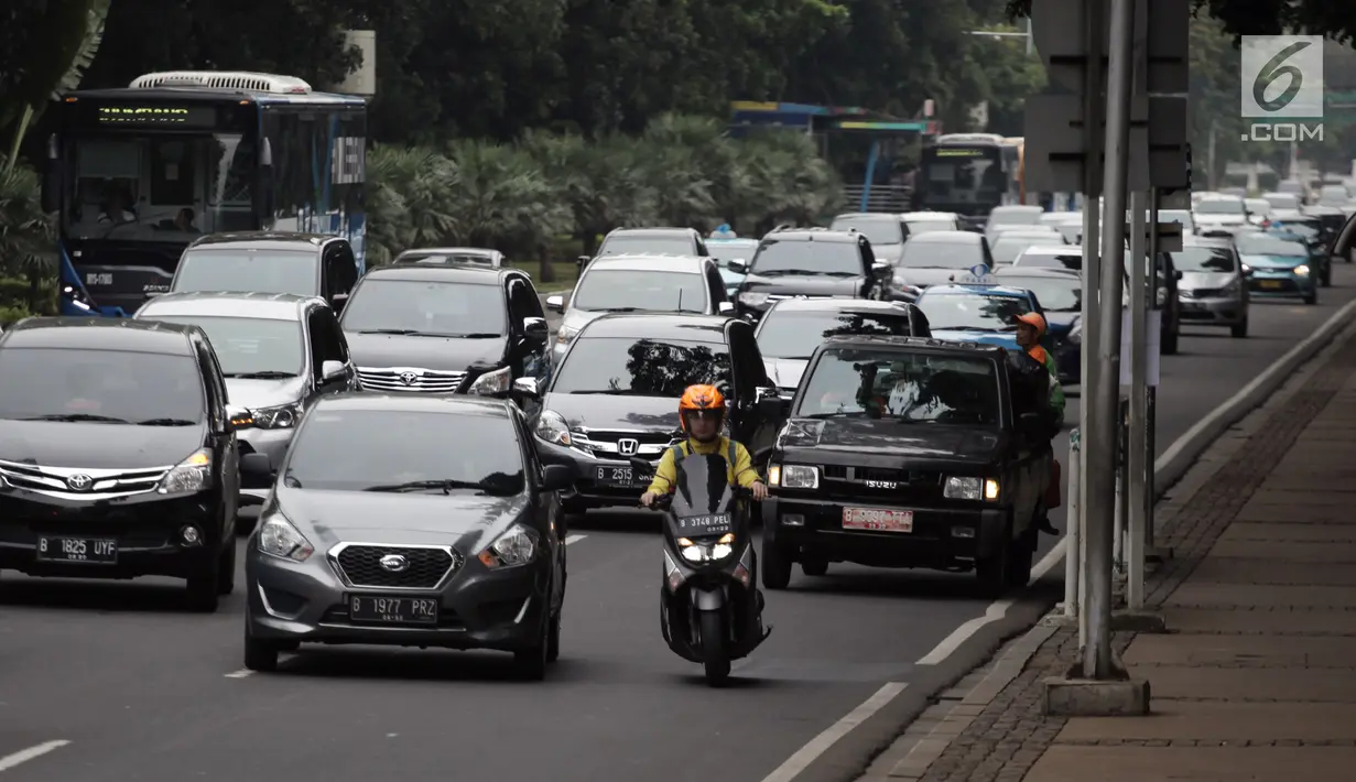 Pengendara motor melintas di antara sejumlah mobil di Jalan MH Thamrin-Medan Merdeka Barat, Jakarta, Kamis (11/1). Ditlantas Polda Metro Jaya menyarankan Pemprov DKI menerapkan sistem ganjil-genap untuk motor di ruas tersebut. (Liputan6.com/Arya Manggala)