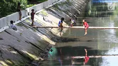Anak-anak bermain di sungai di Jakarta, Sabtu (7/4). Gubernur DKI Jakarta Anies Baswedan memastikan akan tetap membangun Ruang Terbuka Hijau (RTH). RTH yang dimaksud yakni membangun Taman Maju Bersama dan Taman Pintar. (Liputan6.com/Angga Yuniar)