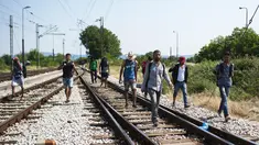 Sejumlah imigran berjalan menyusuri rel kereta api saat perjalanan menuju Gevgelija, wilayah perbatasan Macedonia-Yunani, Kamis (9/7/2015). Mereka menempuh ribuan kilometer agar dapat mengejar kereta api tujuan Serbia. (AFP PHOTO/Robert ATANASOVSKI)