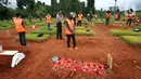 Sejumlah pelanggar PSBB berdoa di makam korban Covid-19 di TPU Jombang, Tangerang Selatan, Senin (18/1/2020). Petugas Satpol PP bersama Polres Tangsel memberikan hukuman bagi 17 pelanggar PSBB yang terkena razia masker di kawasan Bintaro. (merdeka.com/Arie Basuki)