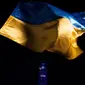 Bendera Ukraina terlihat saat Centre Block of Parliament Hill diterangi dengan warna biru dan kuning Ukraina saat peringatan satu tahun sejak invasi Rusia ke Ukraina di Parliament Hill, Ottawa, Ontario, Kanada, 24 Februari 2023. (Spencer Colby/The Canadian Press via AP)