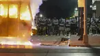Polisi berdiri dekat truk sampah yang terbakar saat protes di Kenosha, Wisconsin, Amerika Serikat, Senin (24/8/2020). Protes dipicu oleh penembakan Jacob Blake oleh petugas polisi Kenosha sehari sebelumnya. (AP Photo/Morry Gash)