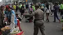 Satpol PP DKI Jakarta menertibkan PKL yang berdagang di kawasan Car Free Day, Bundaran HI, Jakarta, Minggu (20/1). Penertiban dilakukan karena telah membuat ketidaknyamanan bagi para pengunjung CFD yang ingin berolahraga. (Liputan6.com/Faizal Fanani)