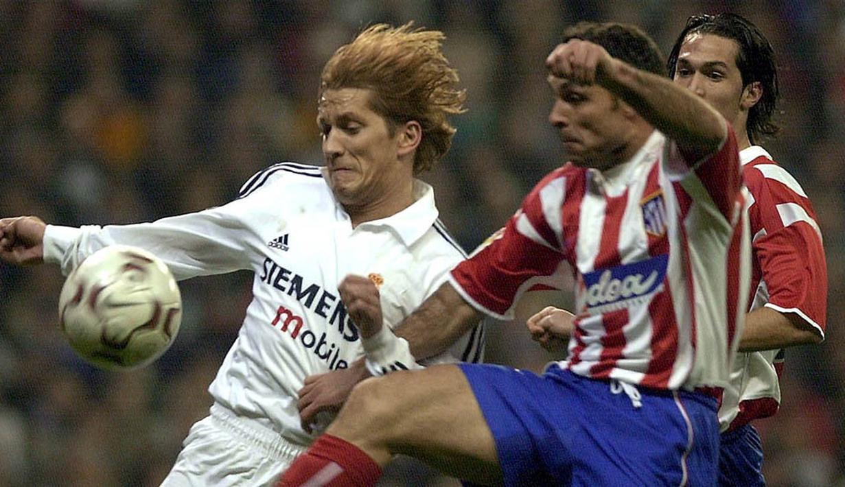 Bek Real Madrid, Michel Salgado, berebut bola dengan pemain Atletico Madrid, Sergi Barjuan, pada laga La Liga Spanyol di Stadion Santiago Bernabeu, Spanyol, Minggu (19/1/2003). (EPA/Paco Campos)