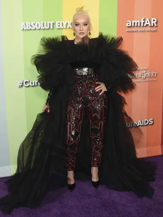 Penyanyi Christina Aguilera berpose saat tiba menghadiri 10th amfAR Gala di Los Angeles, California (11/10/2019). Aguilera tampil anggun dengan gaun hitam serta celana merah berkilau. (AP Photo/Jordan Strauss)