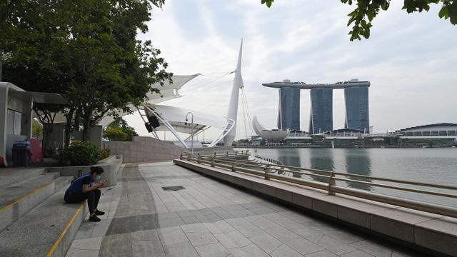 <span>Seorang wanita duduk di Marina Bay di Singapura pada 6 Maret 2020. Tempat-tempat wisata utama di Singapura sepi dari turis di tengah epidemi virus corona COVID-19. (Xinhua/Then Chih Wey)</span>
