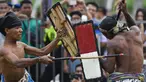Dua pepadu (petarung) melakukan duel dalam kesenian tradisional peresean di Praya, Lombok Tengah, Selasa (19/2). Peresean merupakan kesenian tradisional suku Sasak yang dulunya diadakan setiap musim kemarau panjang. (MOH EL SASAKY/AFP)