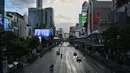 Kendaraan berjalan di persimpangan Ratchaprasong pada hari pertama penguncian COVID-19 yang lebih ketat di Bangkok, Senin (12/7/2021).  Thailand menerapkan lockdown untuk menekan laju penyebaran virus corona pada Senin, 12 Juli 2021 di Bangkok dan provinsi sekitarnya. (Lillian SUWANRUMPHA/AFP)