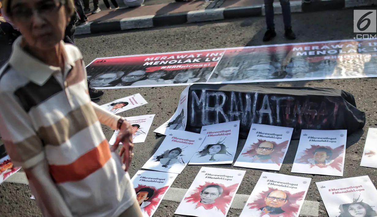 Sejumlah poster terlihat selama aksi bertajuk #MerawatIngat #MenolakLupa saat car free day (CFD) di Bundaran HI, Jakarta, Minggu (5/5/2019). Aksi tersebut bertujuan untuk mengingatkan bahwa masih banyak kasus-kasus pelanggaran HAM berat yang belum terselesaikan. (Liputan6.com/Faizal Fanani)
