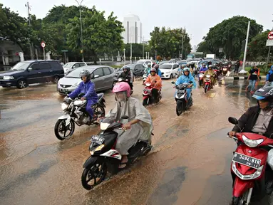 Sejumlah kendaraan melaju melewati genangan air hujan yang merendam jalan di depan Istana Merdeka, Jakarta, Selasa (9/2). Hujan deras yang mengguyur kota Jakarta membuat sejumlah jalan protokol tergenang air. (Liputan6.com/Immanuel Antonius)