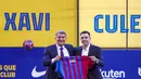 Pelatih baru FC Barcelona Xavi Hernandez (kanan) berpose di samping presiden Joan Laporta selama presentasi resminya di stadion Camp Nou di Barcelona, Spanyol, Senin (8/11/2021). (AP Photo/Joan Monfort)