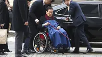 Shin Kyuk-ho tiba di Central District Court di Seoul dengan menggunakan kursi roda (22/12/2017). (AP Photo/Lee Jin-man)