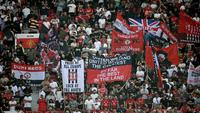 Suporter mengibarkan bendera dan membentangkan spanduk di tribun penonton selama pertandingan Premier League antara Manchester United dan Arsenal di Old Trafford, Manchester, Inggris barat laut, pada 17 Agustus 2025. (Paul ELLIS/AFP)