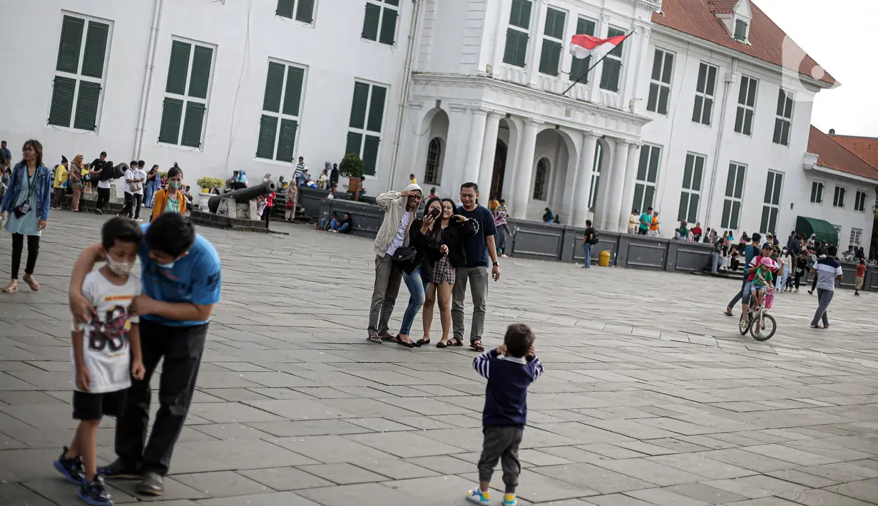 Warga berswafoto di depan Museum Fatahillah kawasan wisata Kota Tua, Jakarta, Senin (23/1/2022). Kawasan wisata Kota Tua yang saat ini terbebas dari pedagang kaki lima (PKL) masih menjadi alternatif warga untuk mengisi liburan, termasuk cuti bersama menyambut perayaan Tahun Baru Imle 2023. (Liputan6.com/Faizal Fanani)