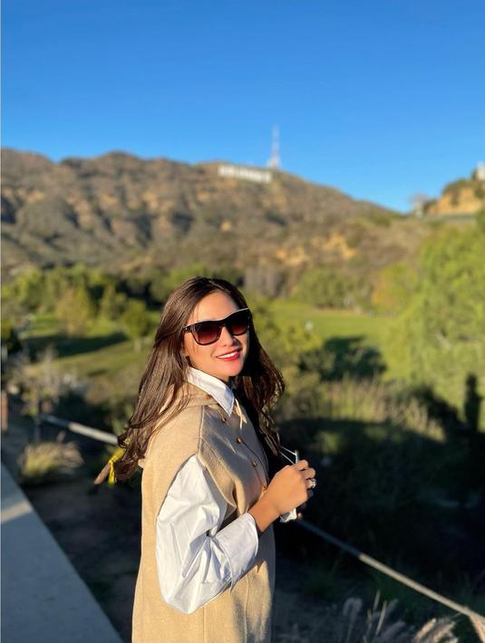 Selain New York, Devina Kirana juga menyempatkan berkunjung ke Los Angeles, Amerika Serikat. Ia berpose dengan latar taman yang luas. (Foto: Instagram/@kiranadevina)