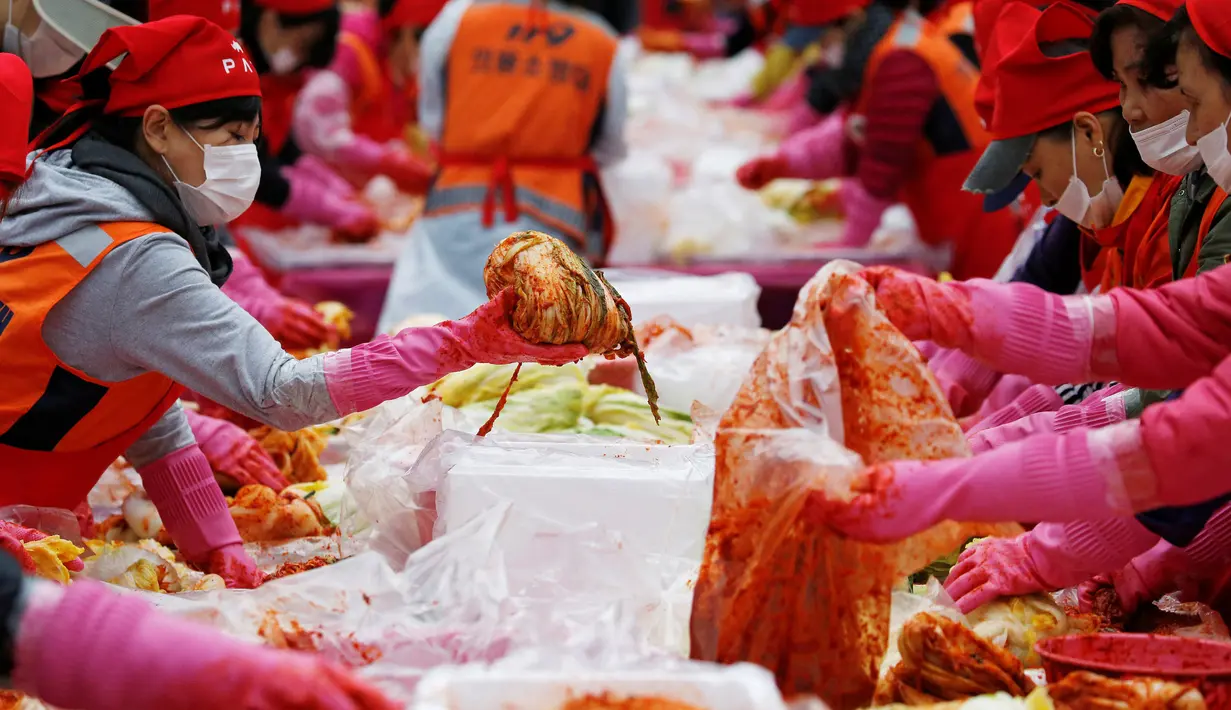 Sejumlah orang membuat Kimchi, hidangan tradisional Korea Selatan, selama Festival Kimchi Seoul di pusat kota Seoul, Jumat (44/11). Kimchi merupakan makanan yang terbuat dari sawi putih atau lobak yang difermentasikan. (REUTERS / Kim Hong-Ji)