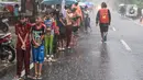 Sejumlah anak-anak antre untuk mendapat takjil gratis di Jalan Cempaka Putih Tengah XXI, Jakarta, Selasa (5/4/2022). Hujan deras yang mengguyur kawasan tersebut tidak menghalangi warga untuk mendapatkan takjil gratis. (Liputan6.com/Herman Zakharia)