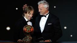 Gelandang Real Madrid, Luka Modric berpose dengan David Ginola setelah memenangkan penghargaan Ballon d'Or 2018 pada malam penganugerahan di Paris, Senin (3/12). Modric menjadi pemain pertama Kroasia yang meraih gelar prestisius ini. (AP/Christophe Ena)