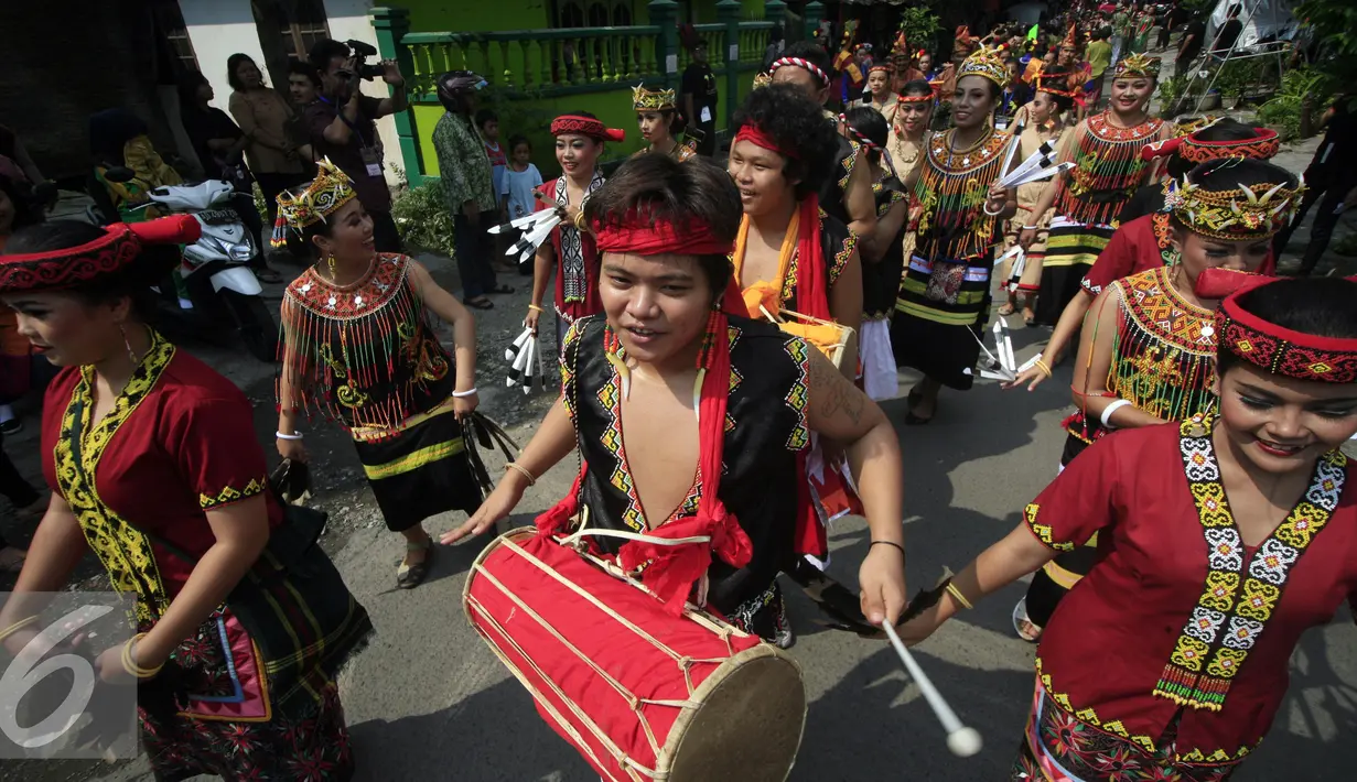 Peserta karnaval mengenakan busana adat dayak saat mengikuti karnaval pembukaan Hari Tari Dunia di kampus ISI Surakarta, Kamis (28/4). Sejumlah penari akan berpartisipasi menari selama 24 jam. (Liputan6.com/Boy Harjanto)