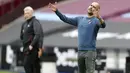 Pelatih Manchester City, Pep Guardiola, memberikan arahan kepada pemainnya saat menghadapi West Ham pada laga lanjutan Liga Inggris di London Stadium, Sabtu (24/10/2020) malam WIB. Manchester City imbang 1-1 lawan West Ham. (AFP/Paul Childs/pool)